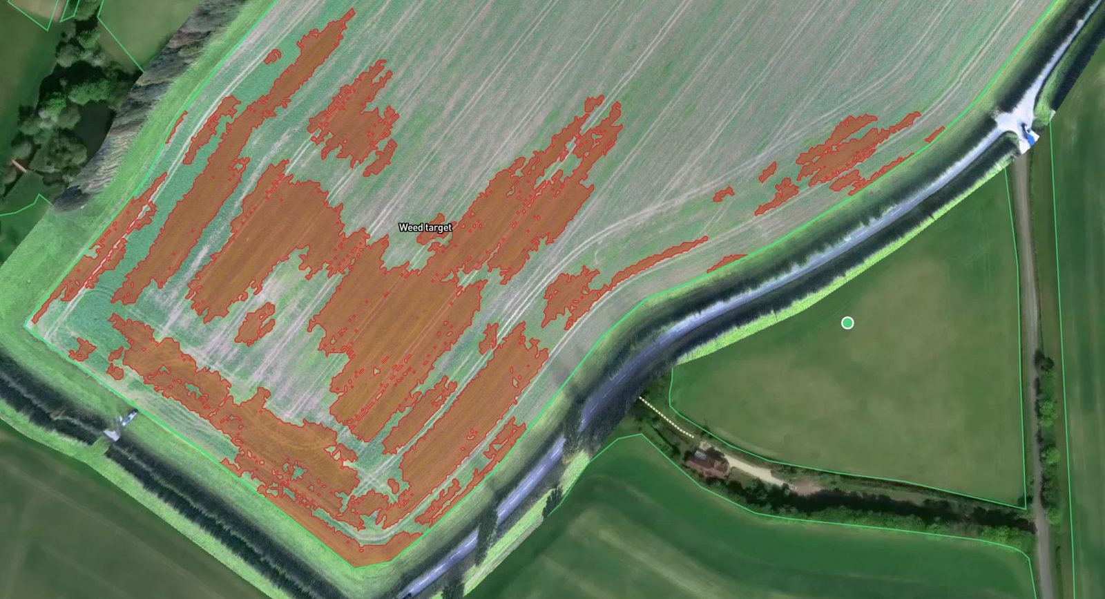 The field with the weed targets shown in red, mostly across the lower half and along the headland.